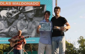 Cristian Mendez, entregando la tablet al ganador del concurso de fotografía