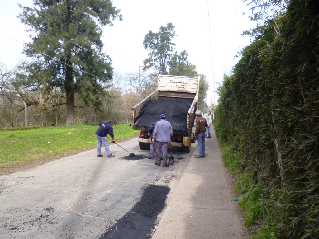 Bacheos con material caliente en calles de asfalto